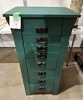 Front view of tall wooden jewelry box painted green with chalk paint and metal drawer handles.