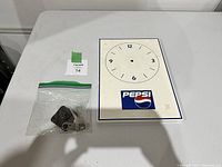 Vintage rectangular tin Pepsi clock face with numbered dial and large Pepsi logo