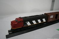 Locomotive and boxcar on short track, showing locomotive number and design details