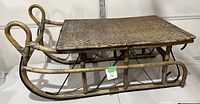 Side view of vintage sleigh coffee table showing wooden frame and woven top