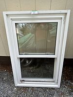 Front view of white vinyl window showing two double-pane sections and overall frame condition.