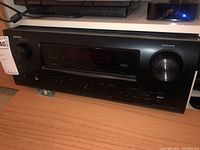 Front view of Denon AVR-2311CI receiver showing model, display, knobs and front panel.