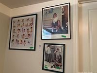 Three framed Norman Rockwell prints hanging on a wall in a basement with various artwork and sizes including 15x13, 21x18, and 25x24 inches.