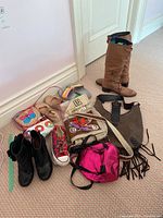 Overview of women's shoes, purses, and accessories included in the lot arranged on floor carpet.