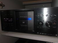 Front view of Sony DVP-CX777ES player showing control panel, display, and disc tray.