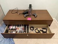 IKEA wooden TV stand with a large drawer open showing video game cases and cables, two Xbox 360 controllers, and the Call of Duty Xbox 360 console on top.