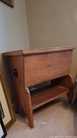Front view of the vintage wooden dough box showing rectangular box and shelf below.