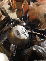 Close-up of golf club heads showing Wilson irons and Titanium Ping 10° driver