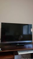 Full front view of Sony Bravia television on stand showing screen and bezel.