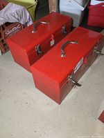 Two red metal Mastercraft toolboxes side by side unopened, showing handles and latches