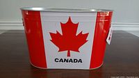 Front view of the metal ice bucket featuring the Canadian maple leaf and word 'CANADA'.