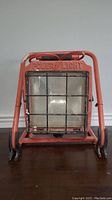 Front view of the red industrial power light showing metal cage and glass front with 'POWER LIGHT' embossed on the frame.