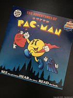 Front cover of 'The Adventures of Super Pac-Man' audio book set showing the book cover artwork and title.
