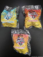 Three sealed Animaniacs Happy Meal toys in original packaging with front view showing character artwork and Happy Meal branding.