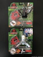 Photo of two Turning Mecard figures still sealed in original packaging; Tanatos and Crang, including their Turning Mecard cards
