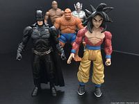 Group front view of 5 figures including Batman, UFC fighter, The Thing, Ultron and Dragon Ball character.