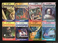 Front covers of 8 Goosebumps books arranged in 2 rows, all authored by R.L. Stine with illustrated horror-themed artwork.