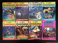 Top-down view of 8 Goosebumps paperbacks laid out in 2 rows showing front covers.
