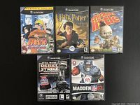 Photo showing front covers of all five Nintendo GameCube game cases and discs: Naruto: Clash of Ninja, Harry Potter: Chamber of Secrets, Chicken Little, Star Wars: Rebel Strike, Madden NFL 07