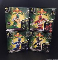 Front view of four new sealed Power Rangers Battle Bike Construction Sets in box, featuring Red, Blue, Green, and Black Rangers, each with 50 pieces for ages 5+