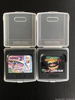 Front view of Sonic 2 and Ayrton Senna's Super Monaco GP Sega Game Gear game cartridges inside clear plastic protective cases.