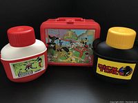 Front view of the three items showing Power Rangers lunchbox in center with Beetlejuice thermos on left and Dick Tracy thermos on right.