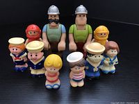 Multiple vintage mini figures arranged on black background showing front views