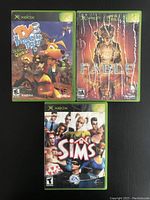 Front of three Xbox game cases: TY3 The Tasmanian Tiger 3, Fable, The Sims