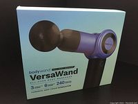 Blue outer box of the bodywand VersaWand massager showing product image and features like 3 power levels, 6 massage heads, and 240 minutes battery life.