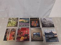 Eight coffee table books laid out in two rows, titles and covers clearly visible.