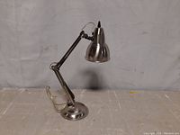 Chrome adjustable table lamp showing overall condition and adjustable arm details.