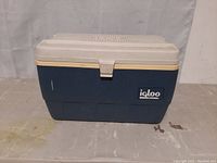 Front view of blue and white Igloo Legend cooler with latch and logo.