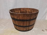 Front view of large oak barrel planter showing wood slats and metal bands