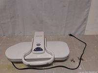Top view of white Singer steam press with control dial and power cord visible.