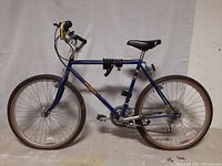 Left side profile of blue Specialized Street Stomper bicycle with 20 inch wheels and cable lock coiled on frame.