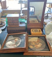 Full view of lot showing Norman Rockwell plates in wooden frames and three different jewelry boxes