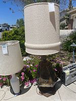 Full view of tall mid-century modern style table lamp with hexagonal detailed base and large textured beige lampshade