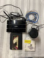 Overview of TP-LINK Archer C5 Router with antennas, black cylindrical internet stick, Ethernet cables, retractable LAN cable in packaging.
