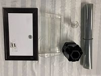Photo shows a dark brown framed magnetic whiteboard, a transparent mountable door mail/paper caddy, a black hexagonal pen/pencil/supplies caddy, and small mounting hardware pieces.