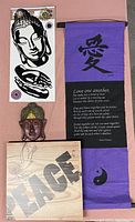 Lot displayed with purple fabric scroll with printed quote and symbol, Buddha mask below, and black and white peel and stick stickers arranged vertically.