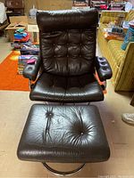 Front view of black leather swivel recliner with matching ottoman