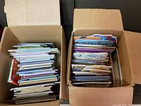 Two open cardboard boxes filled with assorted children's books, viewed from above.