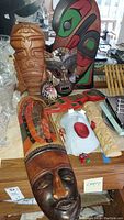 Ethnic carved masks and other assorted wooden ethnic decorative items on a surface