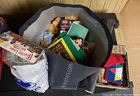 Photo of bags containing LEGO baseplates, travel games, and other toys and books for sale