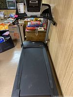 Front view of NordicTrack treadmill in a basement room, showing total length and belt area.
