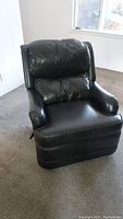 Front view of dark brown leather-like Barcalounger recliner chair on carpeted floor, showing cushioned and slightly wrinkled upholstery.