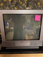 Front view of Sony Trinitron CRT TV showing the screen, bezel, front panel with speaker grills and branding.