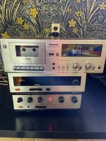 Front view of Panasonic G19 stereo cassette deck with Kenwood KT-2001 tuner and KA-2002 amplifier stacked beneath it. Metal vintage styling.