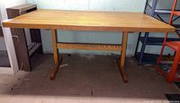 Front view of the rectangular butcher block table with trestle base.