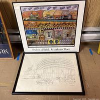 Both framed artworks leaning against wall, showing titles and overall appearance